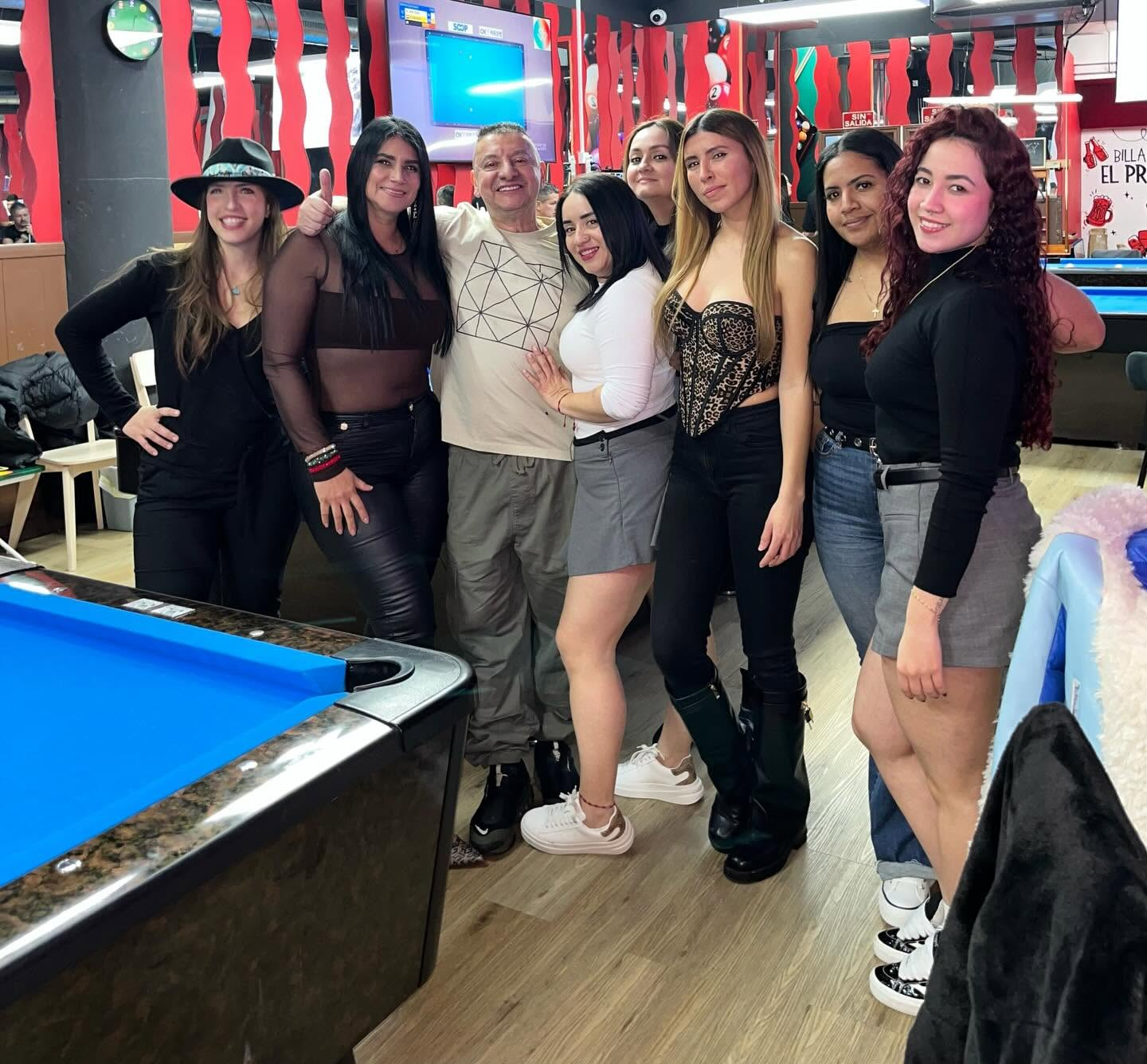Clientes y el equipo de Billares El Primo junto a una mesa de billar